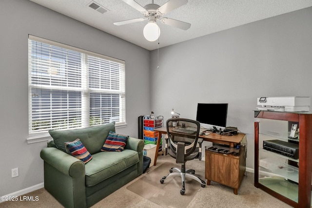 carpeted home office featuring visible vents, baseboards, a textured ceiling, and a healthy amount of sunlight