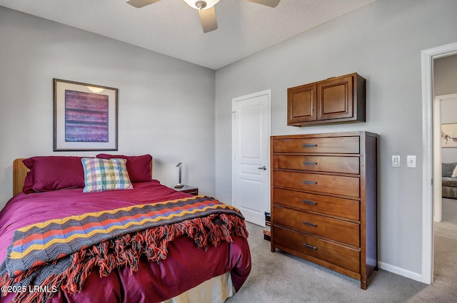 bedroom featuring light carpet, ceiling fan, a textured ceiling, and baseboards