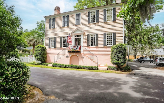 view of front of home featuring a chimney and fence