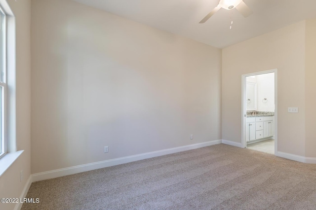 carpeted spare room featuring sink and ceiling fan