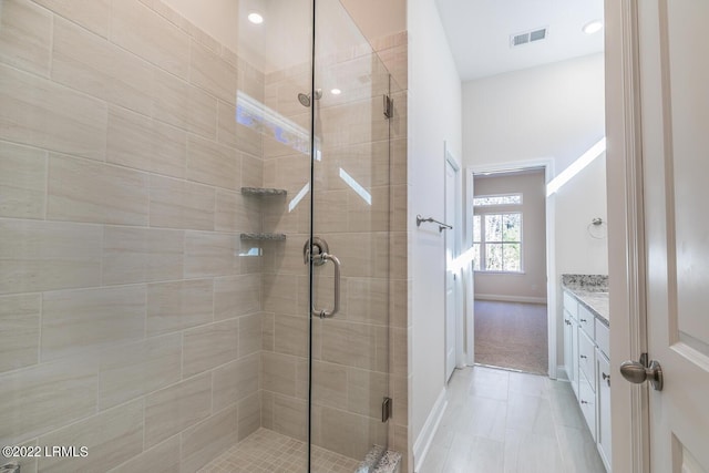 bathroom featuring tile patterned floors, vanity, and a shower with door