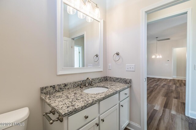 bathroom with hardwood / wood-style flooring, vanity, and toilet