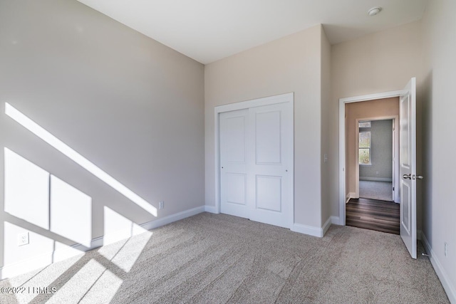 unfurnished bedroom with a closet and light carpet