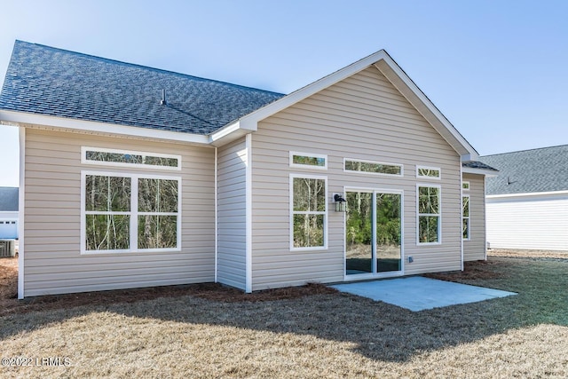 rear view of house featuring central AC unit, a patio area, and a lawn