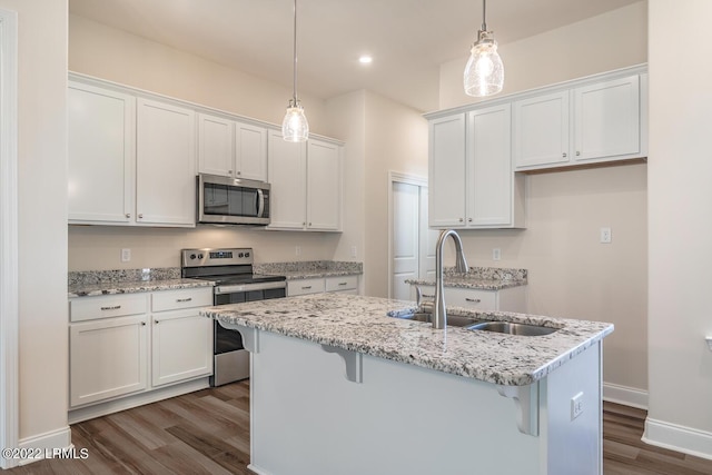 kitchen with pendant lighting, sink, stainless steel appliances, and white cabinets