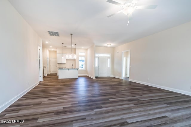 unfurnished living room with dark wood-type flooring, sink, and ceiling fan