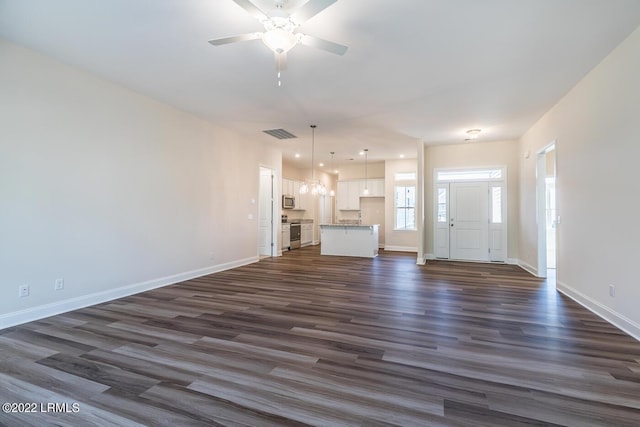 unfurnished living room with dark hardwood / wood-style floors and ceiling fan