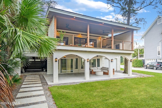 back of house featuring ceiling fan, a yard, a patio area, an outdoor hangout area, and a balcony