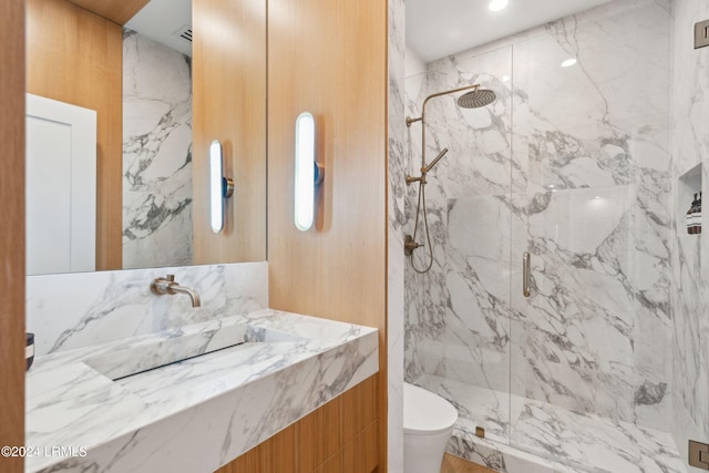 bathroom with vanity, toilet, an enclosed shower, and tile walls