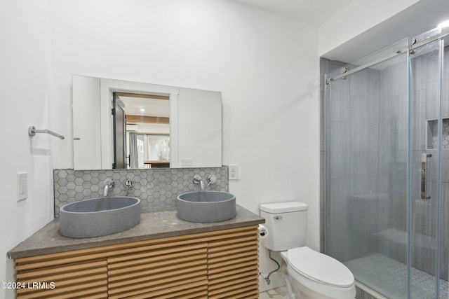 bathroom with tasteful backsplash, vanity, toilet, and walk in shower