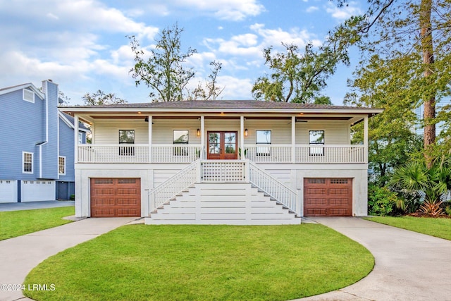 view of front of property with a garage, a front lawn, french doors, and a porch