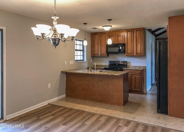 kitchen featuring decorative light fixtures, a textured ceiling, light wood-type flooring, kitchen peninsula, and black appliances