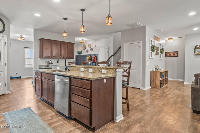 42 Kiawah Dr, Beaufort, SC 29906 - kitchen featuring a sink, stainless steel dishwasher, light wood-style floors, a breakfast bar area, and baseboards