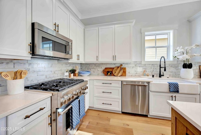 kitchen with white cabinets, appliances with stainless steel finishes, and light countertops