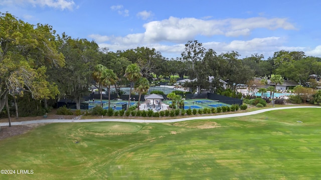 view of home's community with golf course view and a lawn