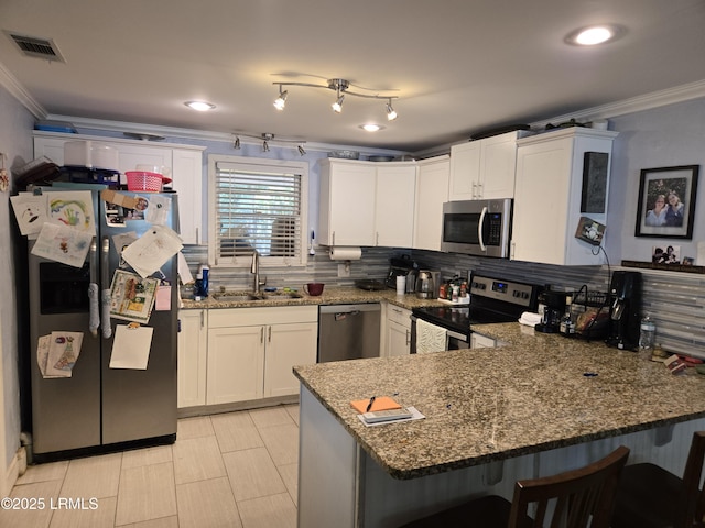 522 Meritta Ave, Beaufort, SC 29902 - kitchen featuring stainless steel appliances, crown molding, a peninsula, a kitchen breakfast bar, and decorative backsplash