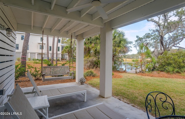 view of patio with a water view and ceiling fan