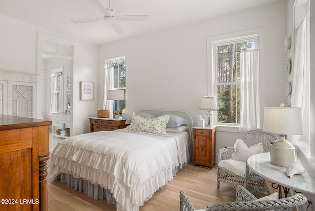 bedroom with multiple windows, ceiling fan, and light hardwood / wood-style flooring