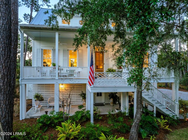 rear view of property featuring a porch and ceiling fan