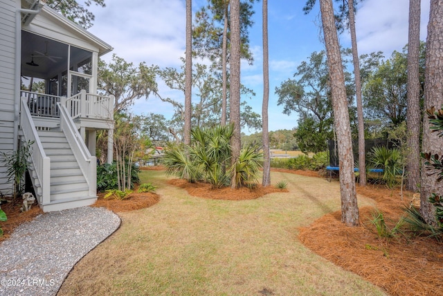 view of yard with ceiling fan and a sunroom