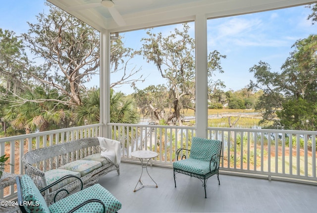 sunroom featuring a water view