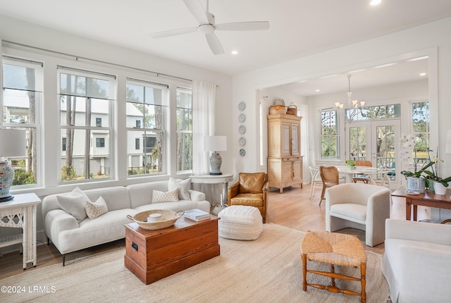 sunroom / solarium featuring ceiling fan with notable chandelier