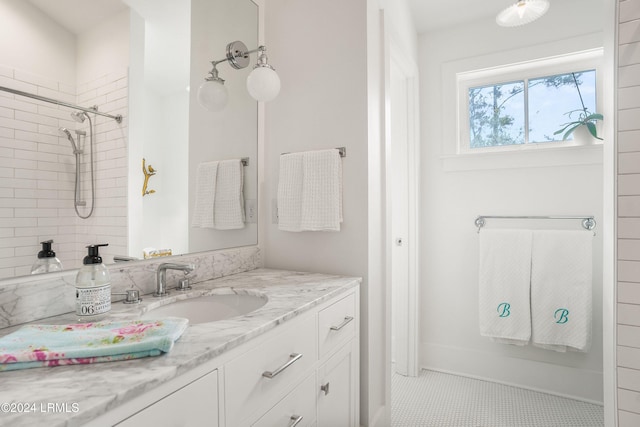 bathroom with vanity, tile patterned flooring, and a tile shower