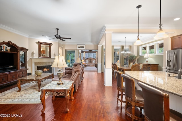 33 Little Pine Ct, Bluffton, SC 29910 - living room with ceiling fan with notable chandelier, a warm lit fireplace, dark wood-type flooring, and ornamental molding