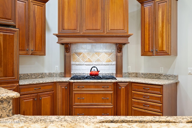 67 Winding Oak Dr, Okatie, SC 29909 - kitchen featuring black gas stovetop, decorative backsplash, brown cabinets, and light stone counters