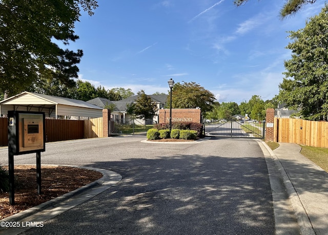 120 Wall St, Savannah, GA 31405 - view of asphalt street with a gate, curbs, street lights, and a gated entry