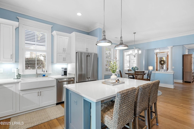 kitchen with sink, a center island, white cabinets, and appliances with stainless steel finishes