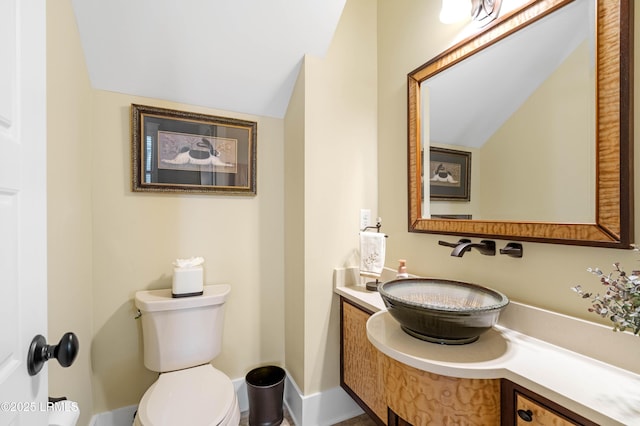 bathroom featuring lofted ceiling, vanity, and toilet