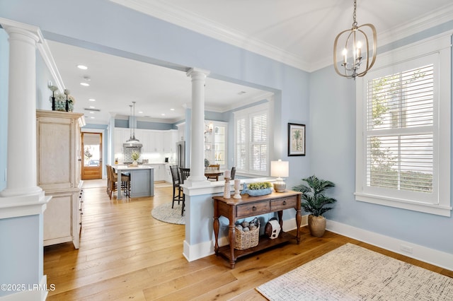 living room featuring ornamental molding, a wealth of natural light, and decorative columns