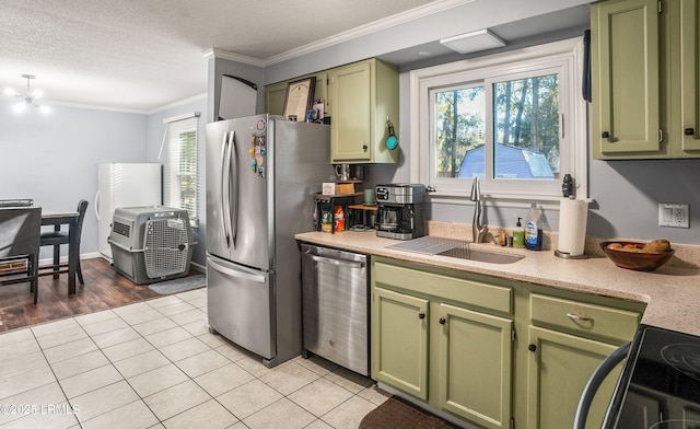 kitchen with sink, light tile patterned floors, stainless steel appliances, and green cabinetry