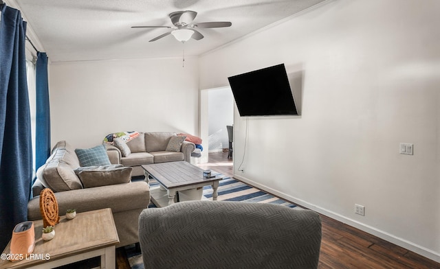 living room with crown molding, dark wood-type flooring, and ceiling fan