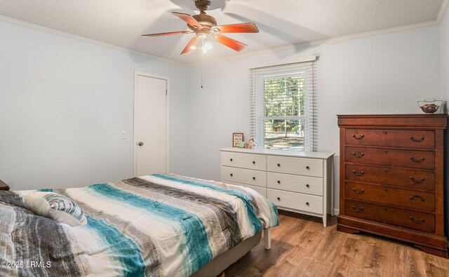 bedroom featuring crown molding, light hardwood / wood-style floors, ceiling fan, and a textured ceiling