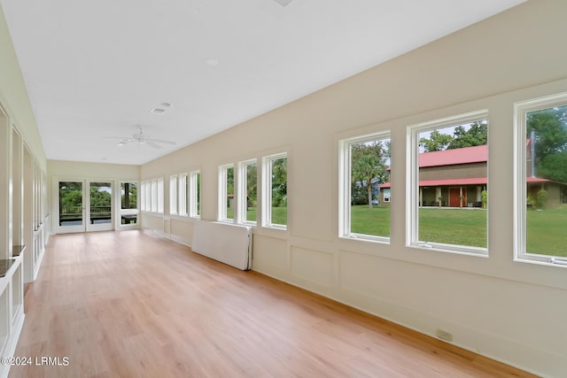 unfurnished sunroom featuring ceiling fan