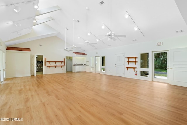 unfurnished living room with ceiling fan, lofted ceiling, and light hardwood / wood-style floors