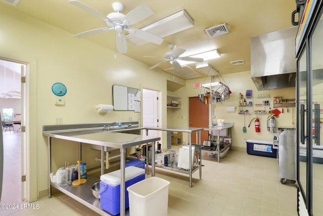 kitchen with stainless steel counters, ceiling fan, and kitchen peninsula