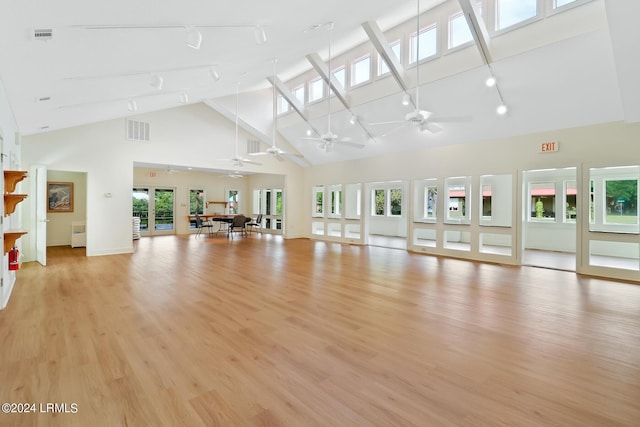 workout room featuring light hardwood / wood-style flooring, a high ceiling, ceiling fan, track lighting, and french doors