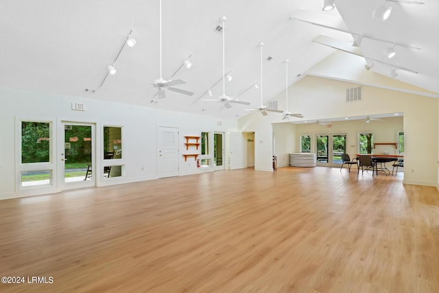 unfurnished living room featuring high vaulted ceiling and light wood-type flooring