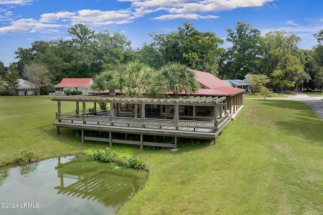 back of property featuring a pergola, a lawn, and a water view