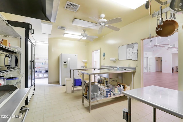 kitchen featuring ceiling fan and white fridge with ice dispenser