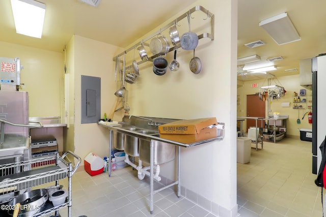 kitchen with tile patterned floors, electric panel, and stainless steel counters