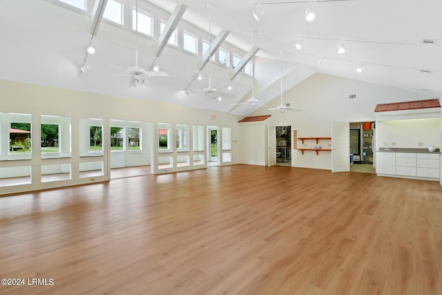 unfurnished living room with ceiling fan, light hardwood / wood-style floors, and high vaulted ceiling