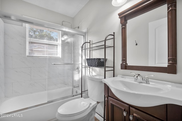 full bathroom with enclosed tub / shower combo, vanity, and toilet