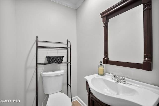 bathroom with crown molding, vanity, and toilet