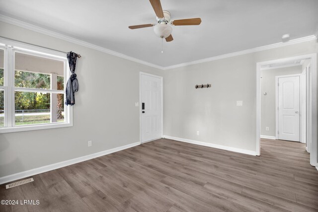 empty room featuring ceiling fan, ornamental molding, and wood-type flooring