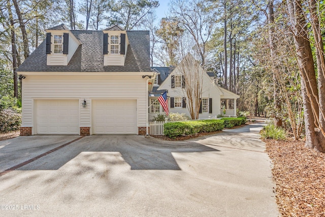 view of front of property with concrete driveway and roof with shingles