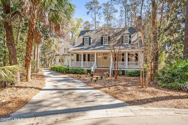 cape cod-style house featuring covered porch and driveway